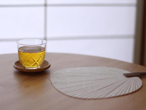 a glass of tea and a plate on a table at Setouchi Mangetsuso in Takamatsu