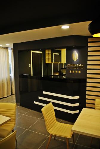 a dining room with chairs and a kitchen on the wall at Panorama Business Inn in Cluj-Napoca