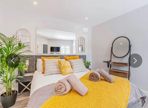 a bedroom with a large bed with yellow blankets and pillows at The Bolthole in Margate