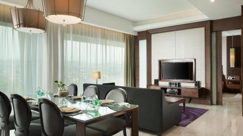 a dining room with a table and chairs and a television at Holiday Inn Bandung Pasteur by IHG in Bandung
