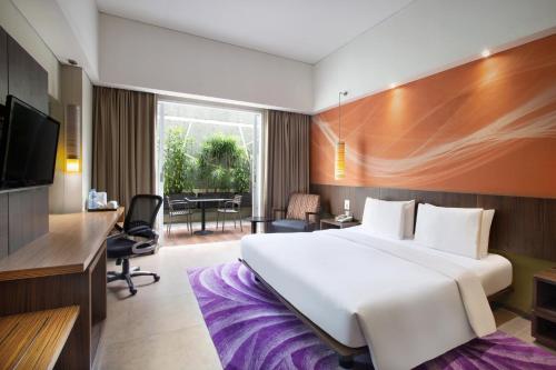 a hotel room with a large bed and a desk at Holiday Inn Bandung Pasteur by IHG in Bandung