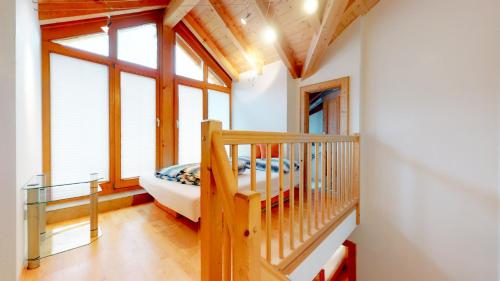 a bedroom with a bed and a staircase in a house at Ferienhaus Monz in Pfunds
