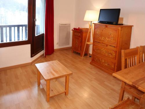 - un salon avec une table et une télévision sur une commode dans l'établissement Studio skis aux pieds avec balcon, centre station - FR-1-322-466, aux Orres