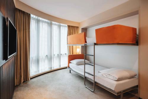 a bedroom with two bunk beds and a large window at Eaton HK in Hong Kong