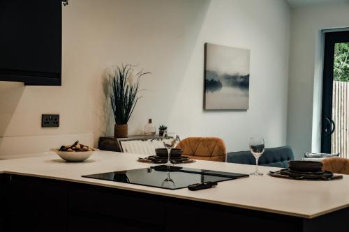 a kitchen with a table with glasses of wine at Bv Luxury 3 Bedroom Townhouse At Bed Cliff Oaks in Leeds