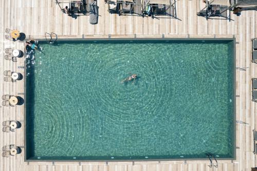 a person swimming in a pool of water at La Mer Resort Spa Crete in Georgioupolis