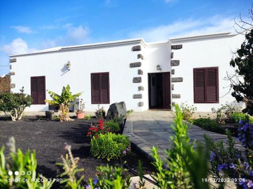 a white building with black shutters on it at Numero28,Casa Tilama in Uga