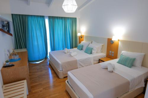 a hotel room with two beds and blue curtains at Royal 1967 in Himare