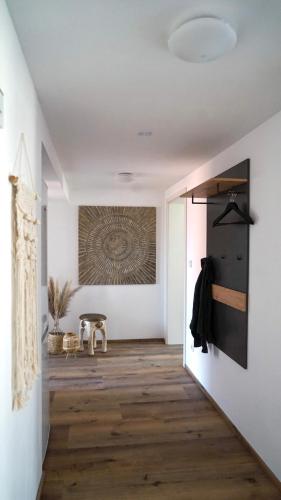 a hallway with white walls and wooden floors and a painting on the wall at CASA CASSAI - Casa Milo in Meiningen