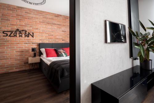 a bedroom with a bed and a brick wall at Loft in Szczecin
