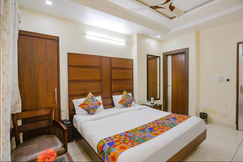 a bedroom with a large bed and a chair at FabHotel Winter Line Inn in Mussoorie