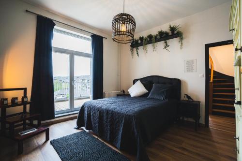 ein Schlafzimmer mit einem Bett und einem großen Fenster in der Unterkunft La Villa Delsa in Namur