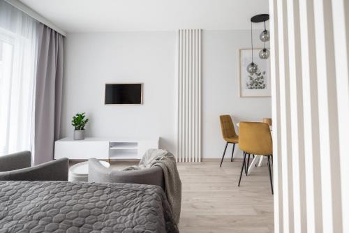 a white bedroom with a bed and a dining room at Scandinavian in Szczecin