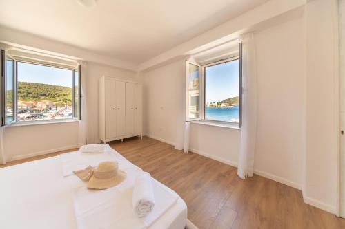 a room with a bed and two large windows at Central Seaside Residence in Vis