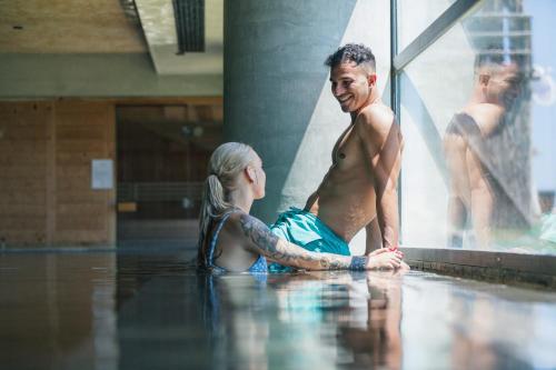 a man and a woman sitting in the water at La Mer Resort Spa Crete in Georgioupolis