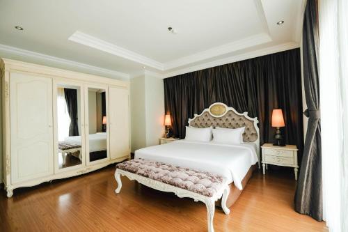 a bedroom with a white bed and a mirror at LK Miracle Suite - SHA Extra Plus in Pattaya South