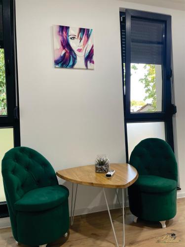 two green chairs and a table in a room at Motel Platani Kotor Varoš in Kotorište