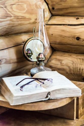 a table with a glass lamp and a book at Srub Karpatský in Vlčeves