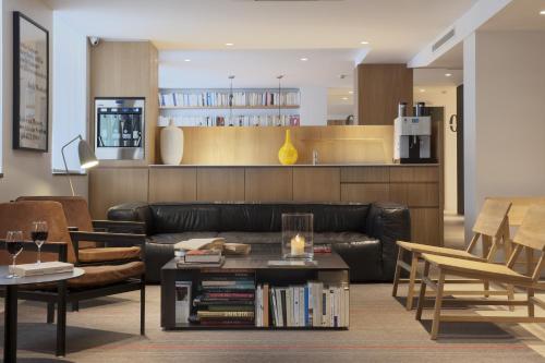 a living room with a leather couch and a table at 9Hotel Opera in Paris