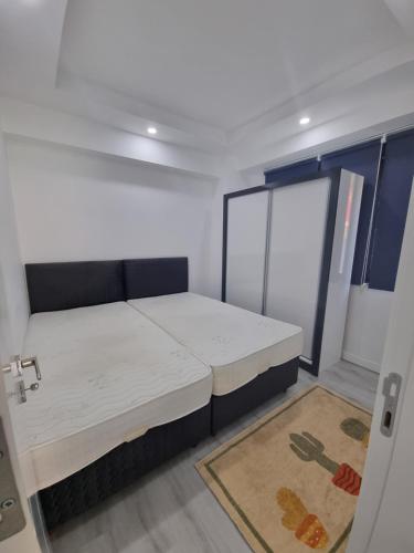 a small room with a bed and a door at Aloha Airport Guest Home in Altınkum