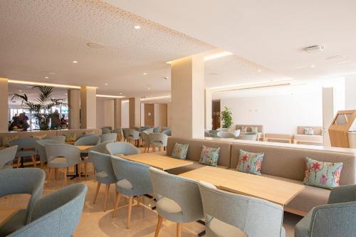 a waiting room with tables and chairs in a hospital at Hipotels Mediterraneo Club in Sa Coma