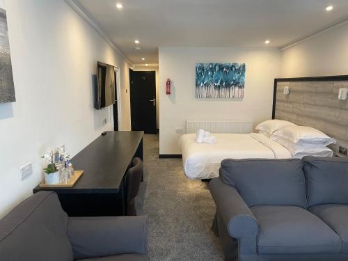 a hotel room with a bed and a couch at TheWaterfrontLodges in Coventry
