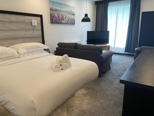 a hotel room with a bed with two towels at TheWaterfrontLodges in Coventry