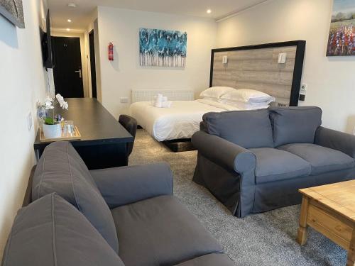 a living room with a couch and a bed at TheWaterfrontLodges in Coventry