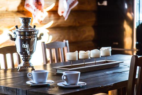 a wooden table with coffee cups and a candle holder at Srub Karpatský in Vlčeves