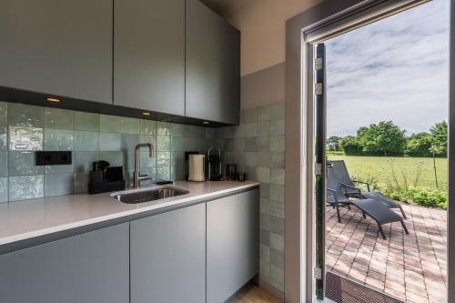 a kitchen with a view of a patio at Villa Magnolia in Oostkapelle