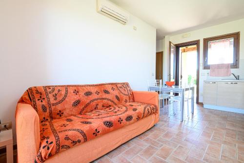 a living room with an orange couch and a table at Residenza Principina in Principina Terra