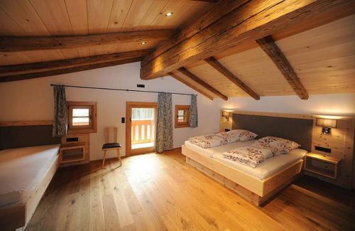 - une grande chambre avec 2 lits et des plafonds en bois dans l'établissement Exenbacher Hof Traumbauernhaus s´Haisl, à Arnbruck