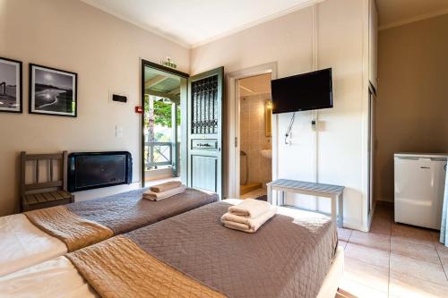 1 dormitorio con 1 cama grande y toallas. en Kalogria Summer Retreats - Seimeio Strofilia, Sunny Vibes, en Kalogria