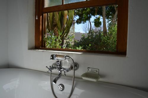 a bath tub with a shower in a bathroom at Ta Mala's Cottage in Prince Albert