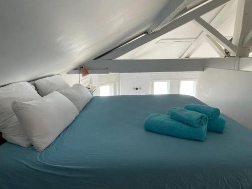 - une chambre avec un lit bleu et des oreillers blancs dans l'établissement 1ère ligne Mer Appartement 7 personnes., à Biarritz