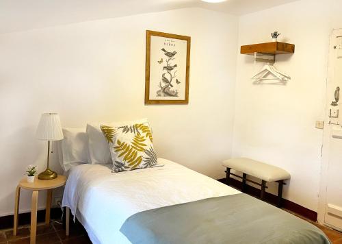 a bedroom with a bed and a table and a lamp at Los Cuatro Cantones - Con BARBACOA in Ariza