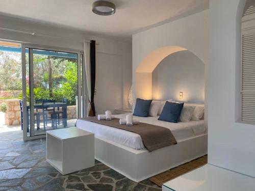 um quarto com uma cama grande e uma varanda em Casa Marimar Boutique Bungalows & Suites em Porto Heli