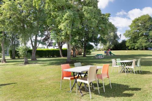 a group of tables and chairs in a park at Holiday Inn Lille Ouest Englos, an IHG Hotel in Englos