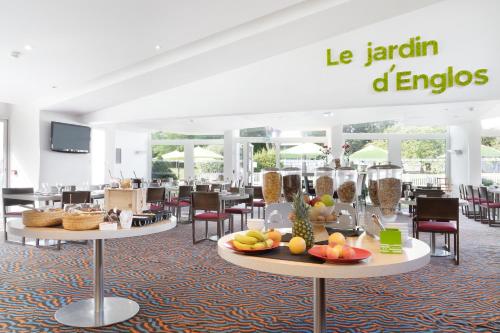 a restaurant with tables and chairs with fruit on them at Holiday Inn Lille Ouest Englos by IHG in Englos