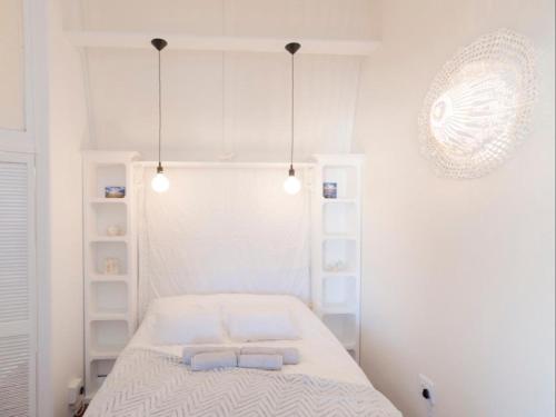 una camera bianca con un letto e due asciugamani di Beach Cottage Kleinzee a Kleinsee