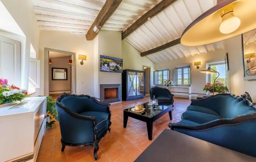 a living room with blue chairs and a table at Borgo Scopeto Wine & Country Relais in Vagliagli