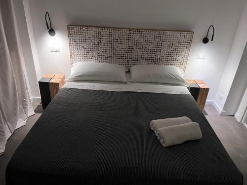 a bed with a black blanket and a pillow on it at Villa Chiara Taormina in Taormina