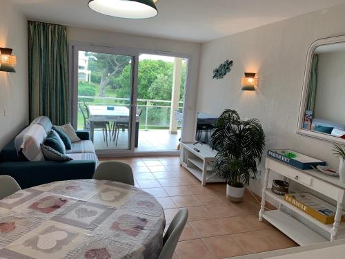 un salon avec une table et un canapé et une salle à manger dans l'établissement Appartement avec grande terrasse dans un magnifique parc à 5 minutes de la plage, à La Baule