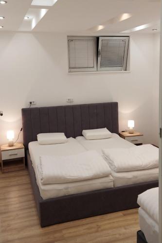a bedroom with a large bed with two night stands at Apartman Dona in Banja Luka