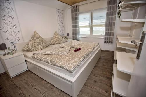 um pequeno quarto com uma cama com uma flor vermelha em Ferienhaus Therese em Kobern-Gondorf