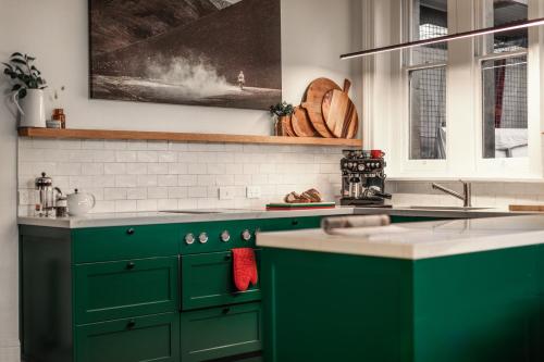 ホバートにあるEuropean Style Houseのキッチン(緑のキャビネット、シンク付)