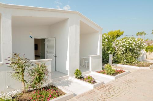 a white house with flowers in the courtyard at Sant'Elia Deluxe Rooms in Vieste