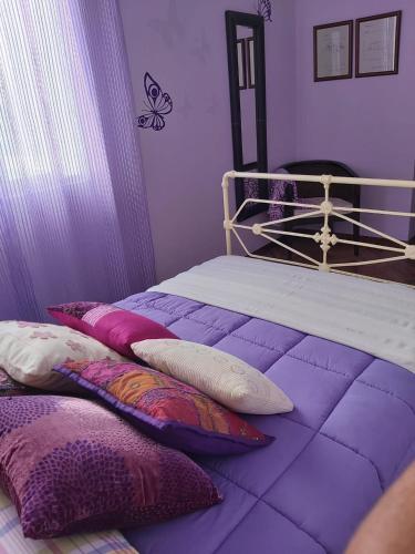 a purple bedroom with a bed with pillows on it at JALEPA in Muxia