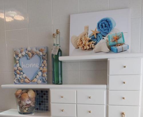 a white shelf with shells and a picture of a heart at JALEPA in Muxia
