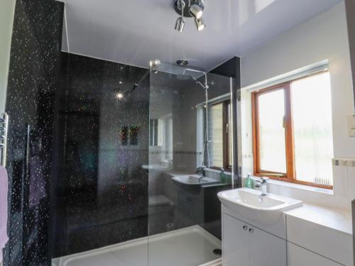 a bathroom with two sinks and a shower at The Cottage in Talacre